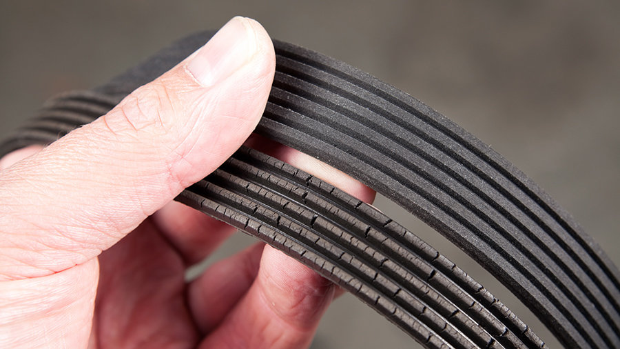 One old and and worn out serpentine belt is compared beside a new one.