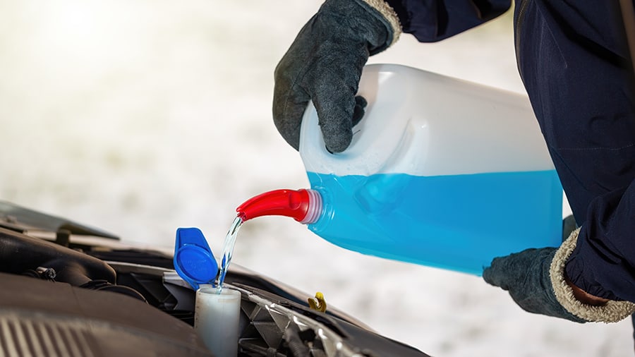 Topping up a car's engine coolant.
